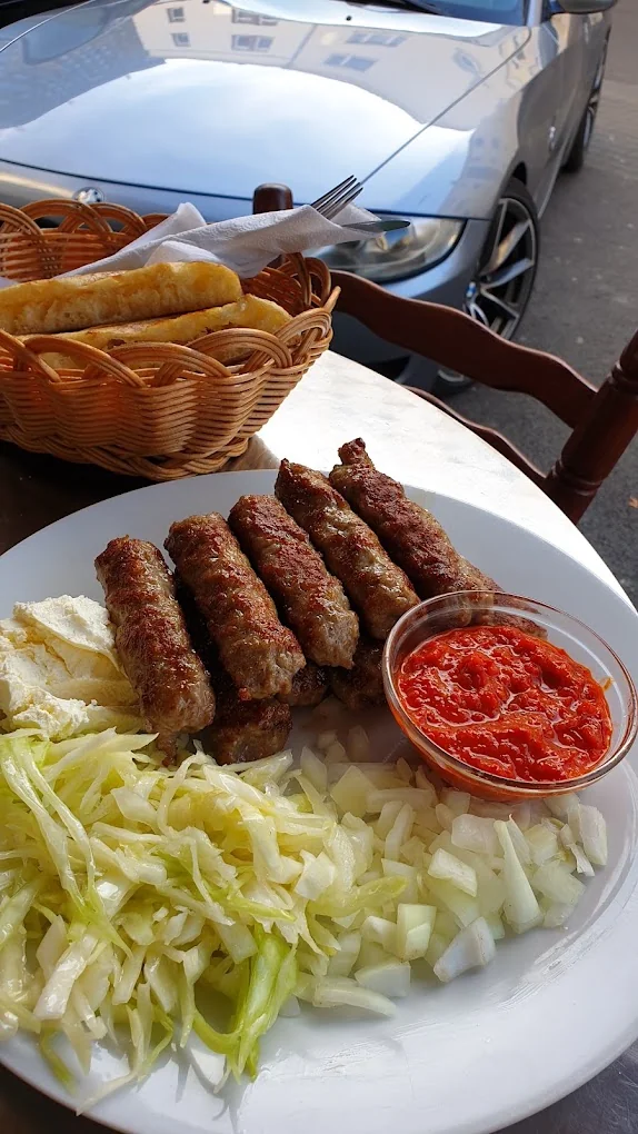 Originalaufnahme von gegrillten Ćevapi mit Ajvar und Zwiebeln
